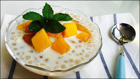 코코넛 밀크를 넣은 망고 디저트와 스푼