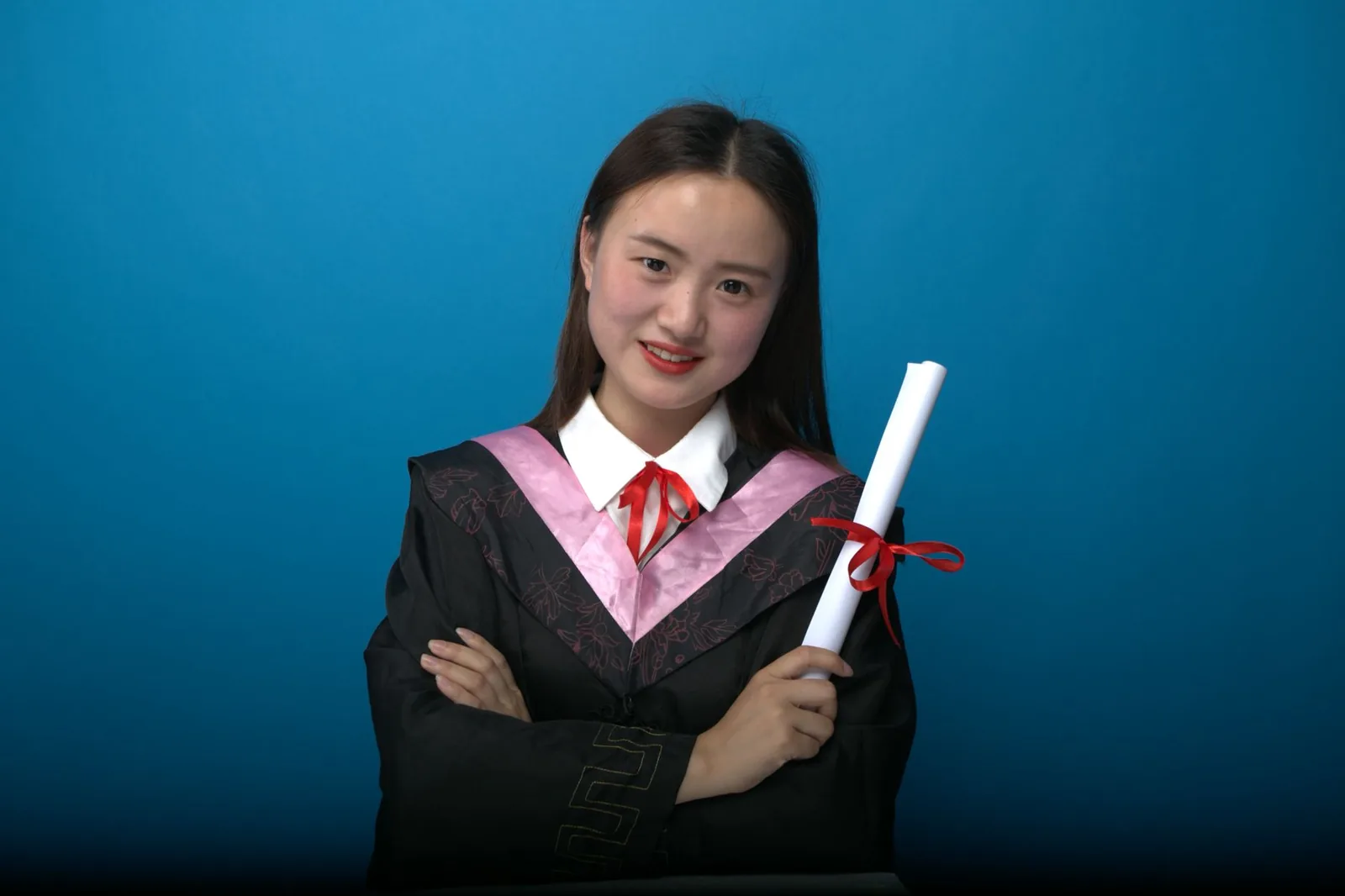 모자와 가운을 착용한 자신감 넘치는 졸업생이 졸업장을 들고 있으며, 파란색 배경.