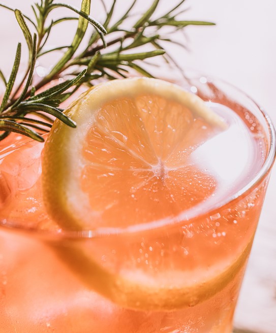 컵안에 핑크색의 음료와 레몬 허브가 올라가있다.