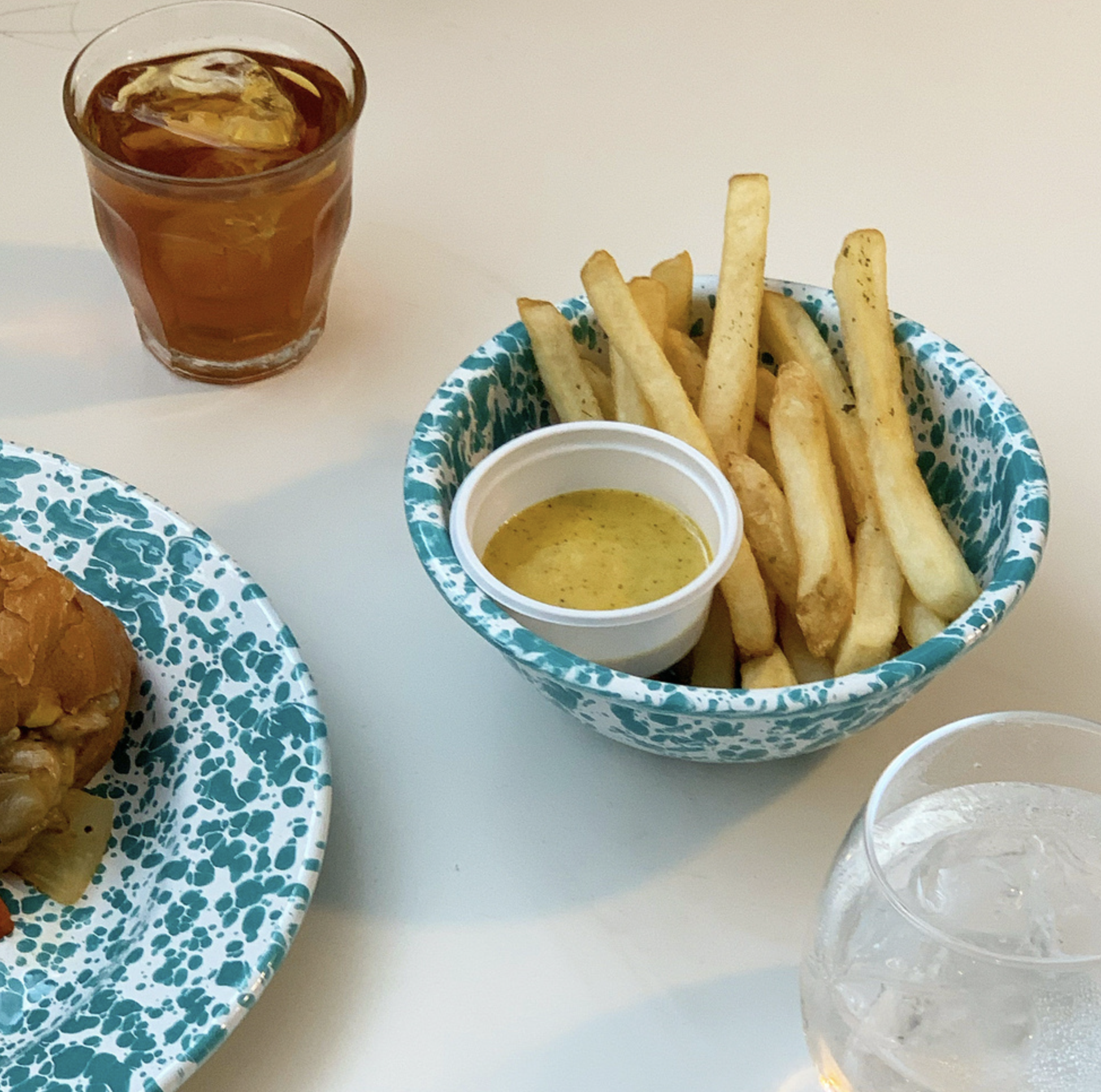 청록색 법랑 그릇에 감자튀김 담긴 모습