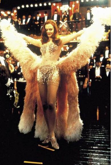 영화 물랑루즈 한 장면. 여성 배우가 깃털이 무대의상을 잎고 팔을 벌리고 있음