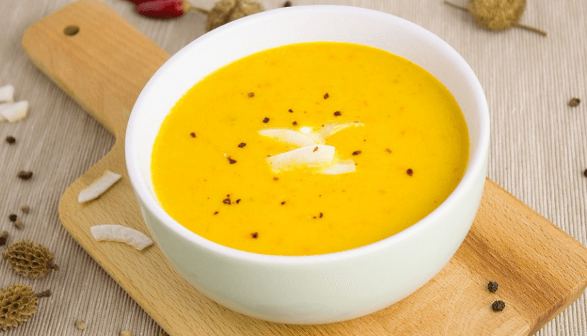 하얀색 그릇 안에 맛있어 보이는 호박 수프가 담겨 있다