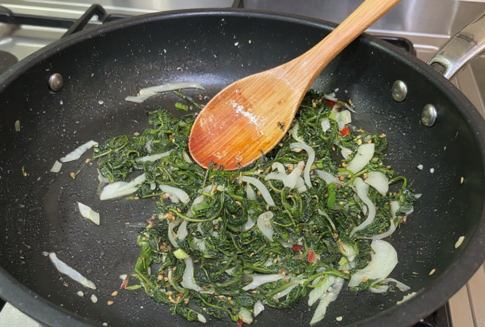 팬에 양념한 깻잎순과 양파를 넣고 들기름에 볶고 있는 모습