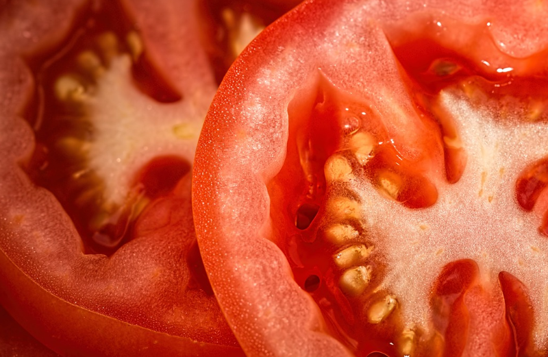 슬라이스한 잘 익은 토마토&#44; 과즙과 토마토 씨가 있음