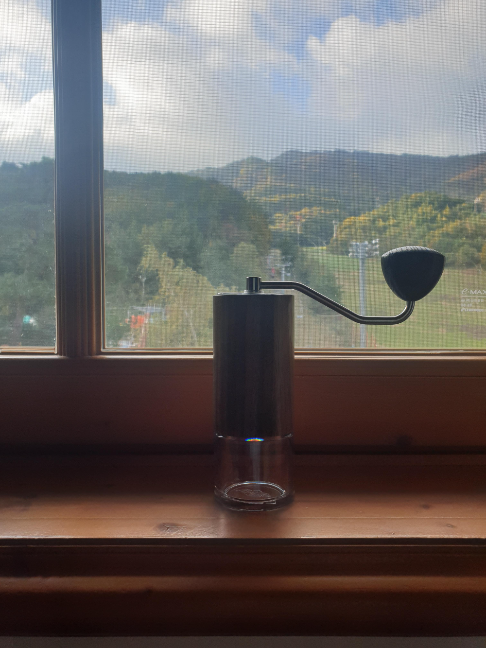 스키장이 보이는 창문 앞에 그라인더가 놓여있다.