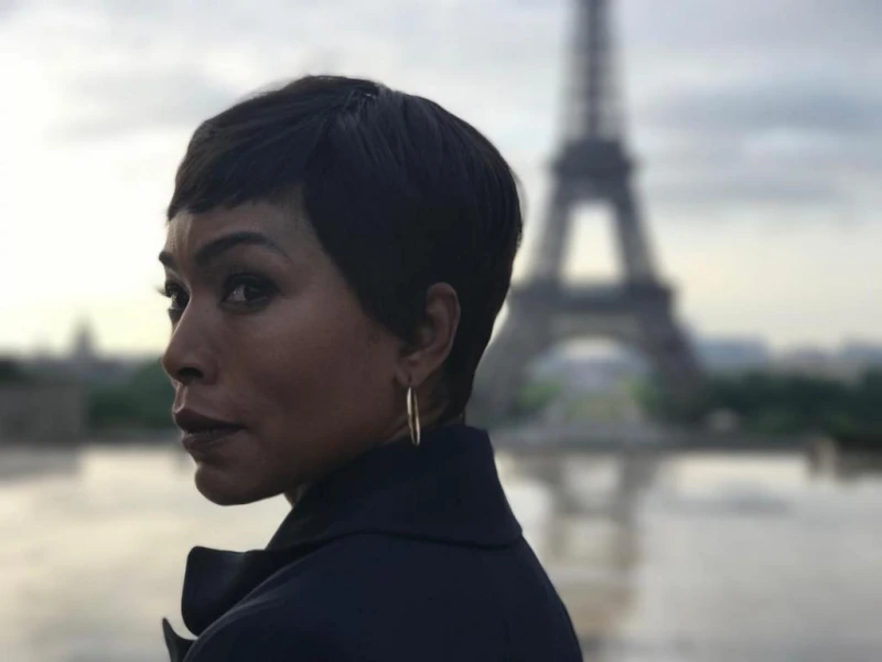 파리를 배경으로 검은 정장코트를 입은 검고 짧은 숏컷을 한 미션 임파서블 7 출연진 안젤라 바셋