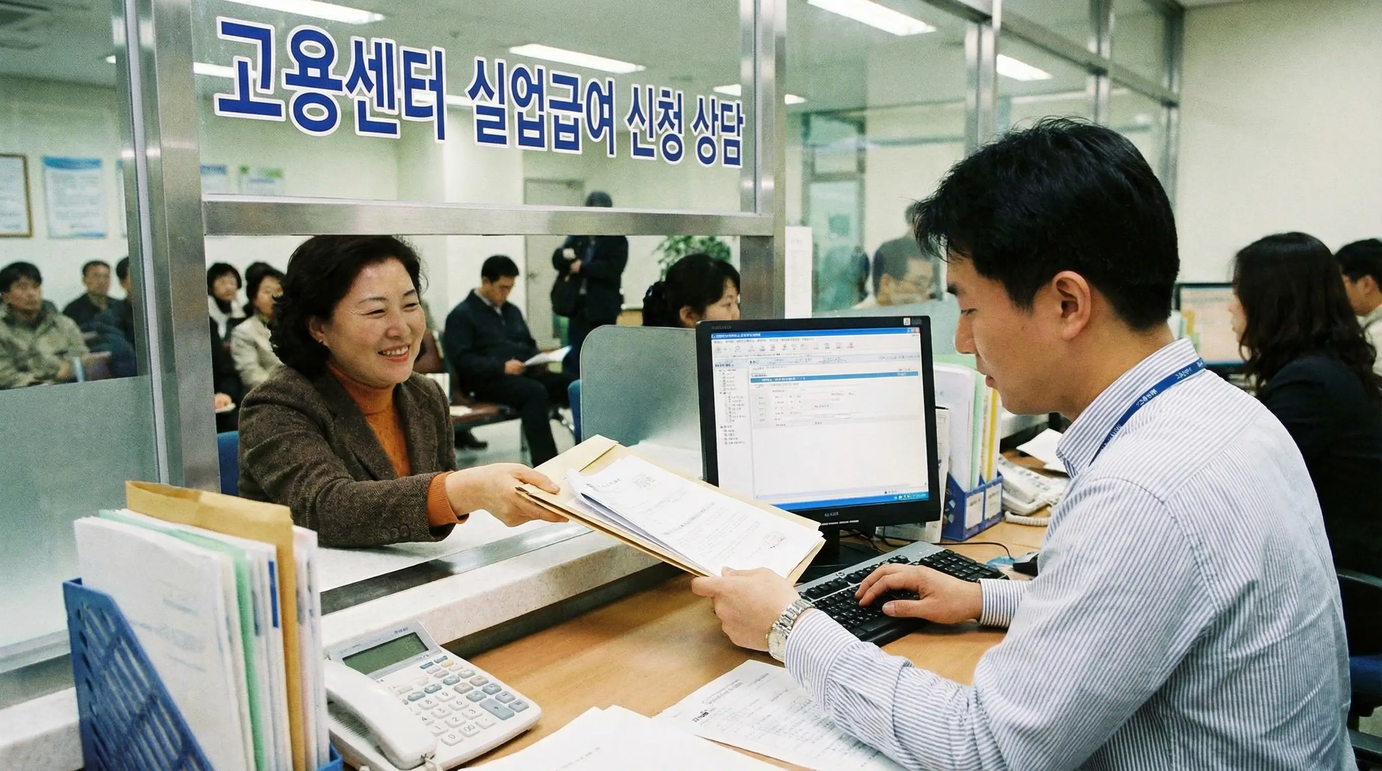 고용센터 상담 창구에서 직원에게 서류를 제출하며 실업급여 신청 상담을 받는 모습