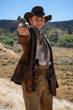 서부영화에서-황량한-벌판에서-카우보이-모자를-쓴-남성이-총을-겨누고있는-모습