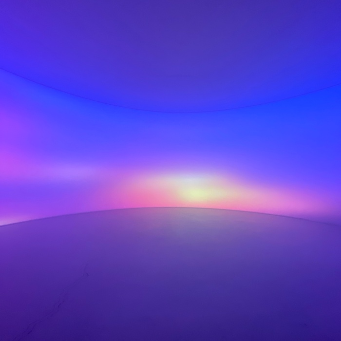 노을빛과 오로라 빛이 굴곡된 벽면에 투사되어 있습니다.