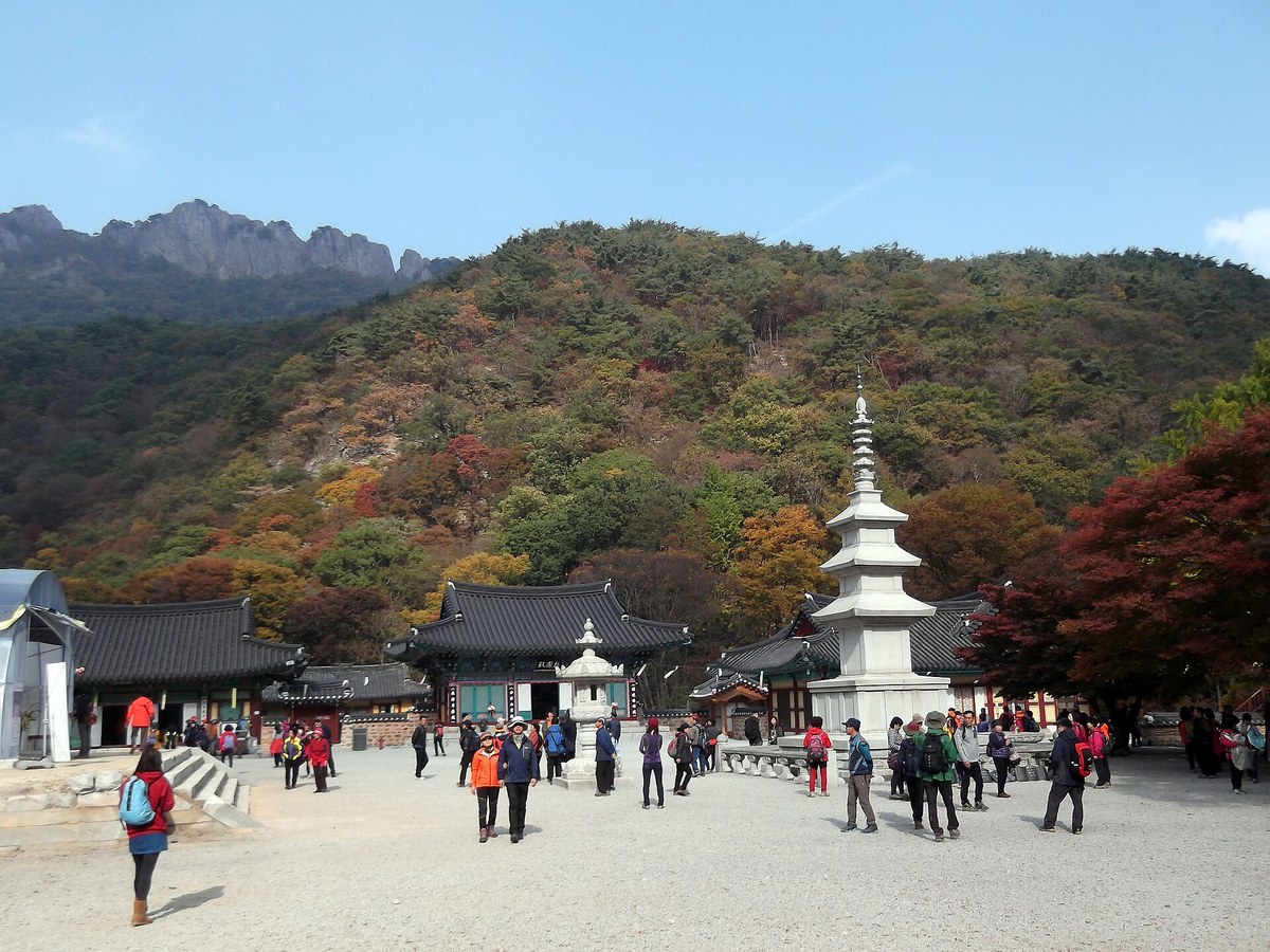 A temple courtyard in Naejangsan National Park with autumn-colored hills and rocky ridges behind