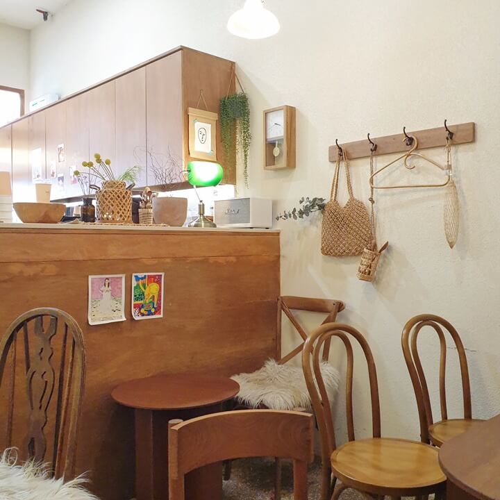 아이보리-우드톤의-인테리어와-라탄-및-우드-소재의-소품들이-왼쪽-테이블-위에-있고-오른쪽엔-옷걸이가-있다