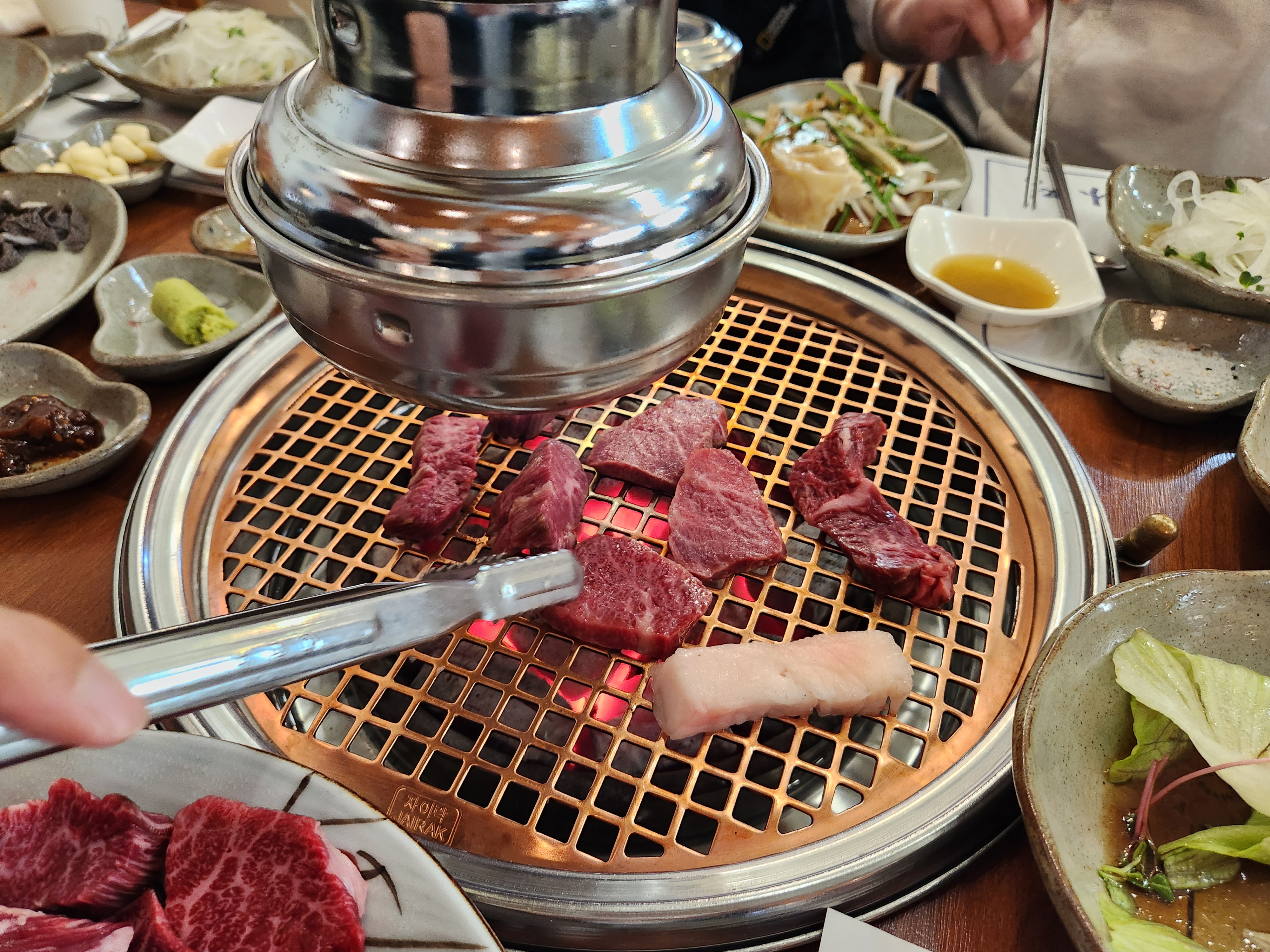 숯불에 소고기를 굽고 있다.