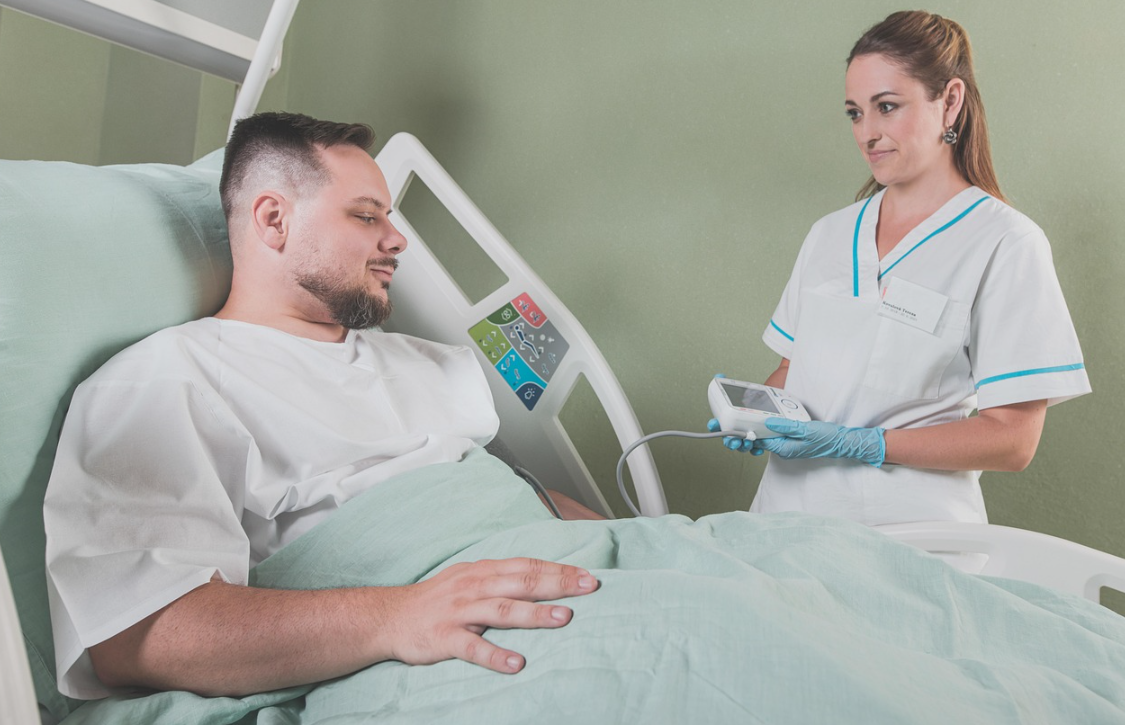 환자 옷을 입고 병원 침대에 누워 검사 받는 남자 환자 사진