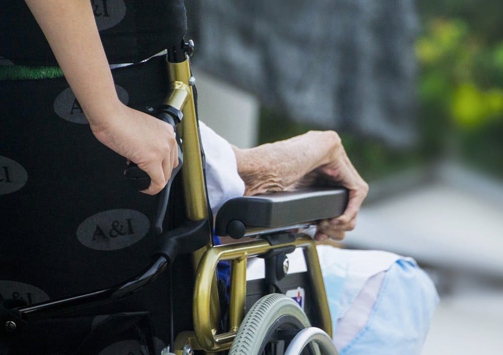휠체어를 타고 있는 노인과 보호자