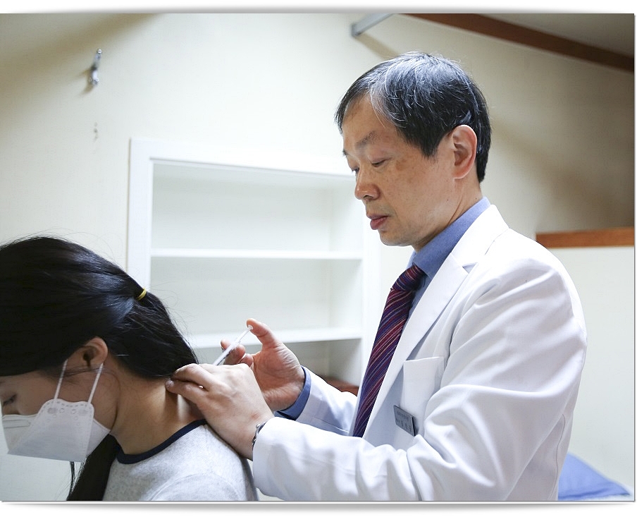 환자의 목 뒤에 약침을 놓고 있는 한의사의 모습