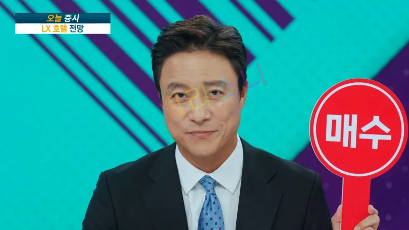 뉴스 방송 스튜디오에서 오천수(최대천)이 정장을 입고 카메라를 바라보고 있다. 그는 푸른색 넥타이를 맨 검은색 정장을 입고 있으며&amp;#44; 한 손에 