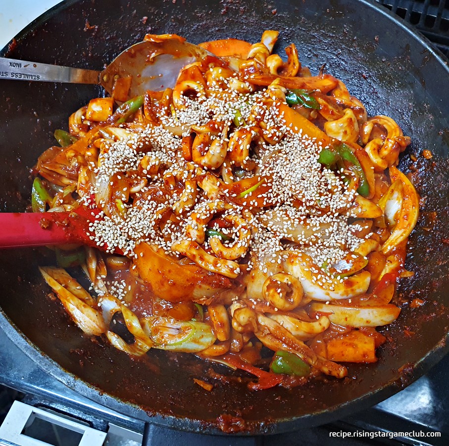 맛있는 오징어볶음에 통깨를 뿌리는 사진