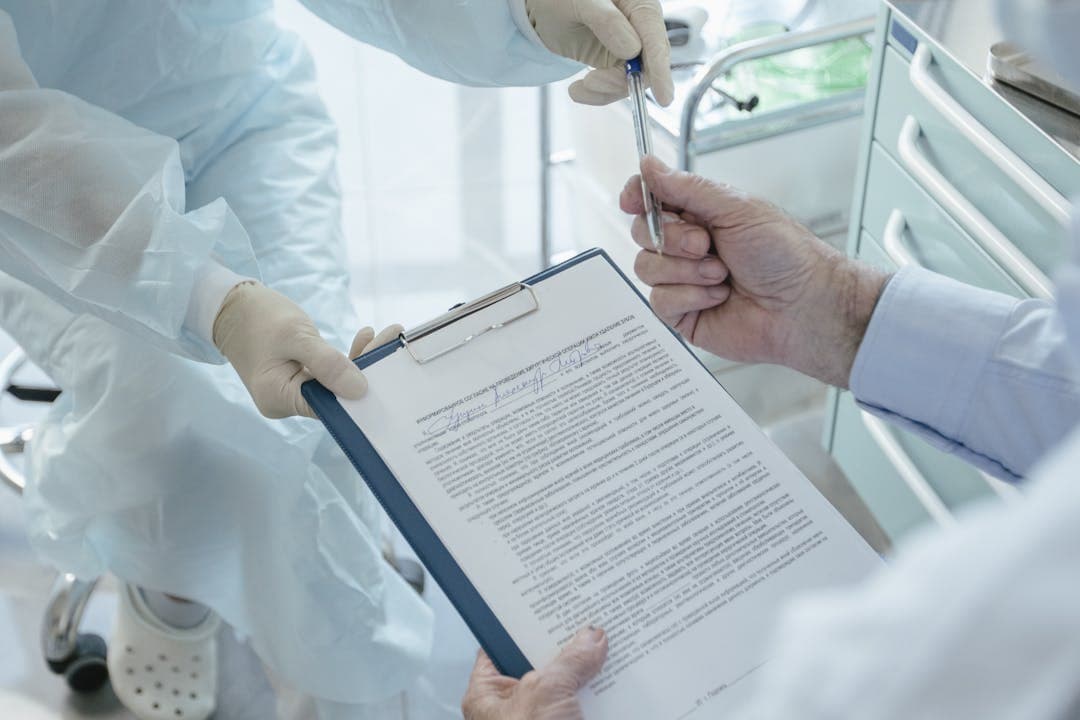 의료진이 클립보드에 문서를 건네며 서명을 요청하는 모습