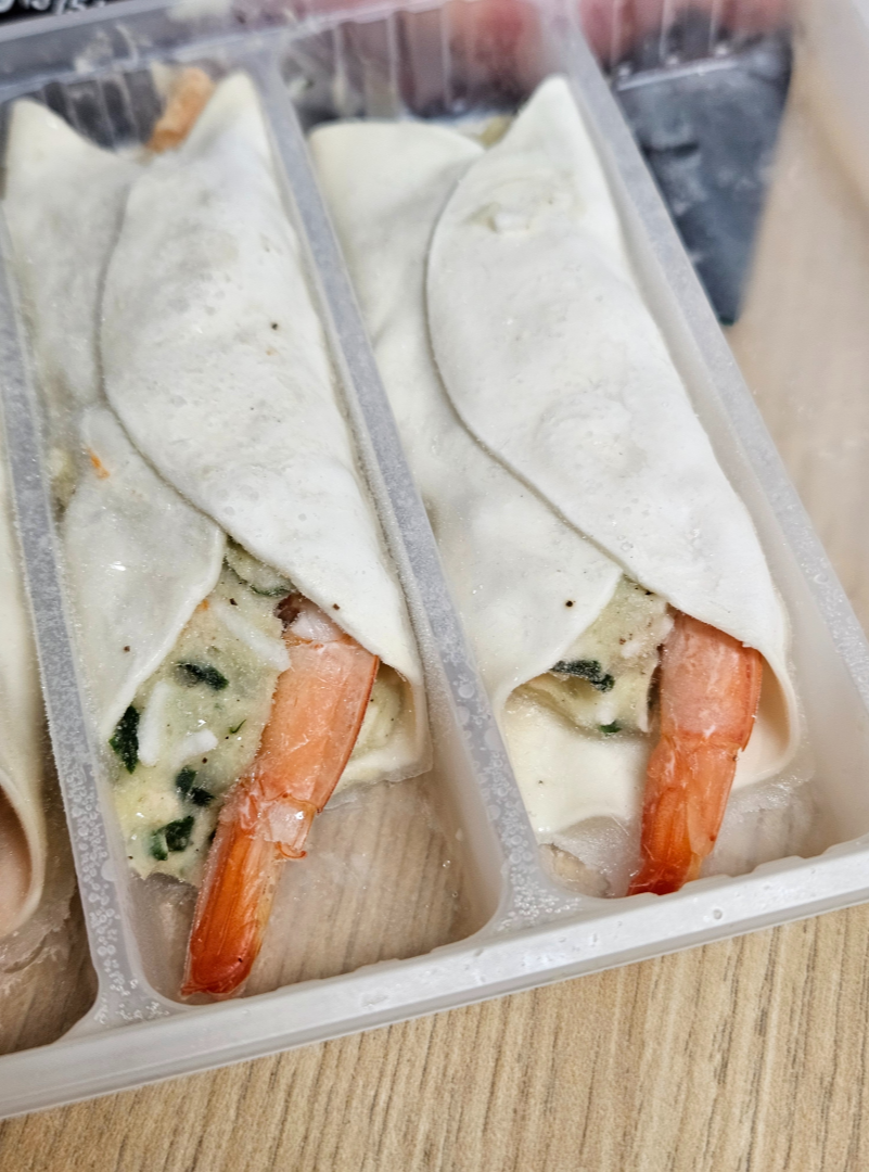 비비고 통새우만두 개봉 후 트레이에 담긴 냉동 만두 모습을 확대한 모습으로&amp;#44; 새우 꼬리가 밖으로 튀어나온 모습