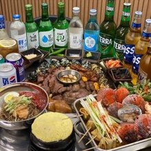 고기를-먹으며-소주병이-테이블에-줄을-서있는-장면