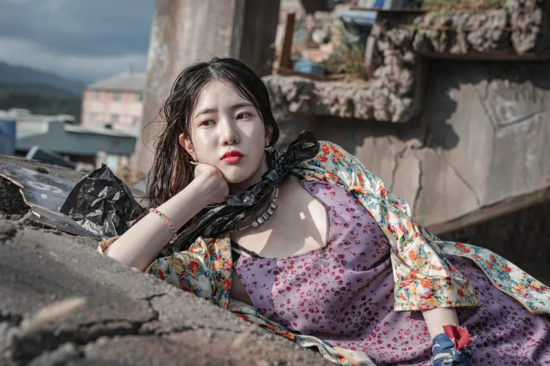 무너진 폐허에서 섹시한 원피스를 입고 누워 있는 스위트홈 시즌2의 정예슬을 연기하는 배우 양혜지