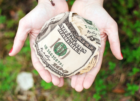 손에 달러를 올려 놓은 사진