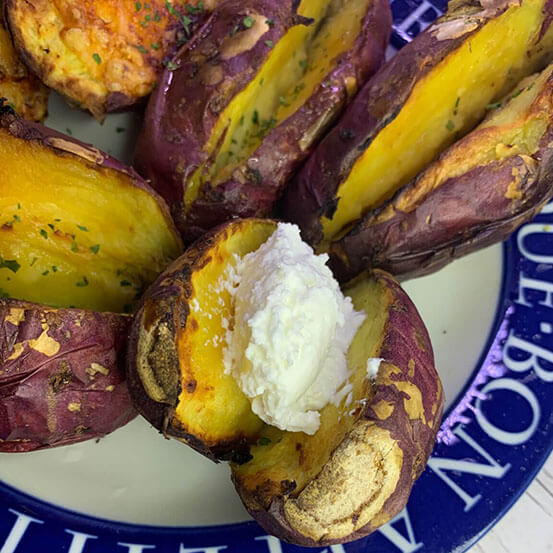 에어프라이어에 먹음직스럽게 구운 고구마를 반으로 가르고 그 사이에 그릭요거트를 한 스푼 얹었다.