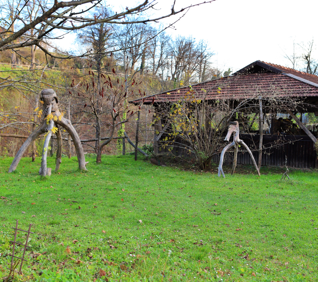 마당에 설치된 솟대 형태의 독특한 목재 조형물과 라스토케 전통 가옥 - Unique Wooden Sculptures and Traditional House in Slunj
