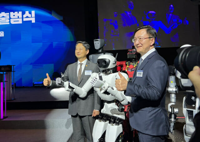 안덕근 산업통상자원부 장관(왼쪽)과 유홍림 서울대학교 총장(오른쪽)이 10일 K-휴머노이드 연합 출범식에서 에이로봇의 휴머노이드 '앨리스'와 기념 사진을 찍고 있다.