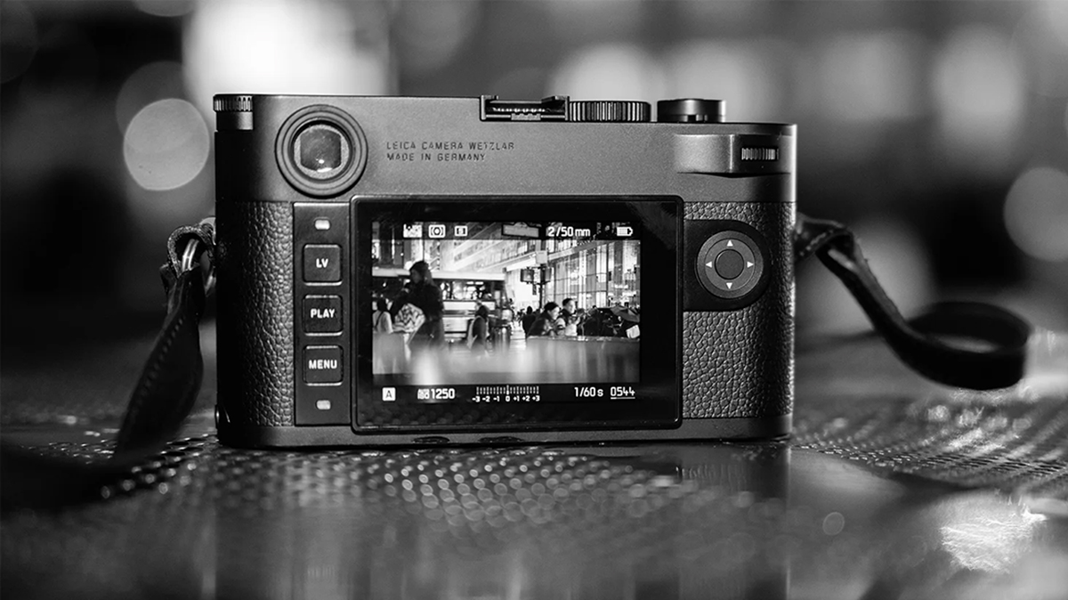 테이블 위에 올라와 있는 라이카 M10 모노크롬 바디의 후면을 촬영한 흑백사진. LCD 창에는 흑백 사진으로 촬영하고 있는 모습이 담겨있다.