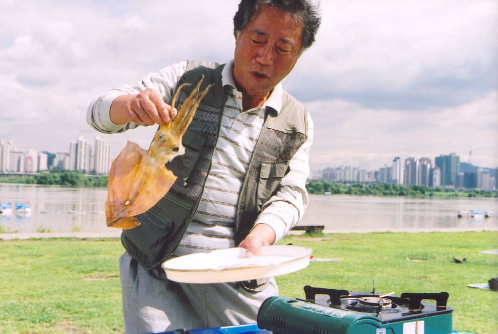 오징어를 굽고 있는 박희봉 역의 배우 변희봉