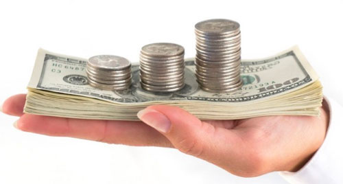 손바닥위에 지폐와 동전이 쌓여있음