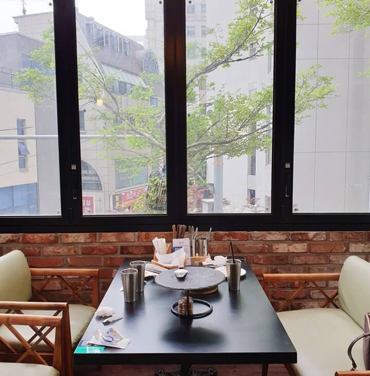 이올로화덕피자-창가자리-테이블과-의자가-있다