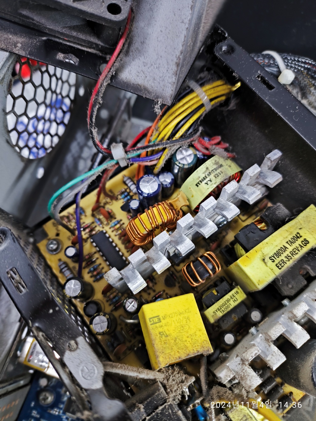 고장난 파워서플라이를 분해해보고 있습니다. 콘덴서가 터졌네요.