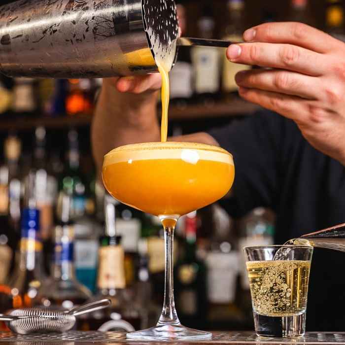 셰이커에서 부드러운 거품과 함께 잔에 담기는 폰스타 마티니 제조 과정