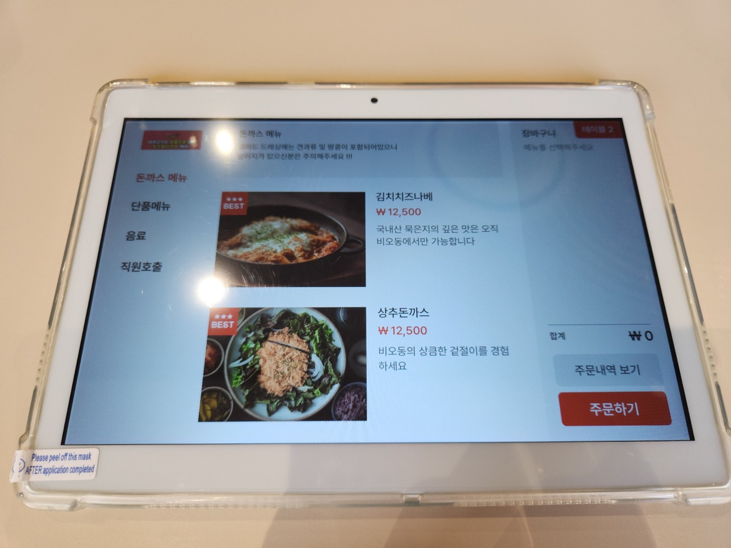 돈까스를 주문할 수 있는 기기의 모습. 화면에 김치 치즈 나베와 상추 돈까스가 보인다.