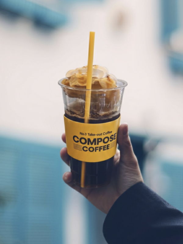 하늘을 향해 컴포즈 커피를 들고 있는 모습