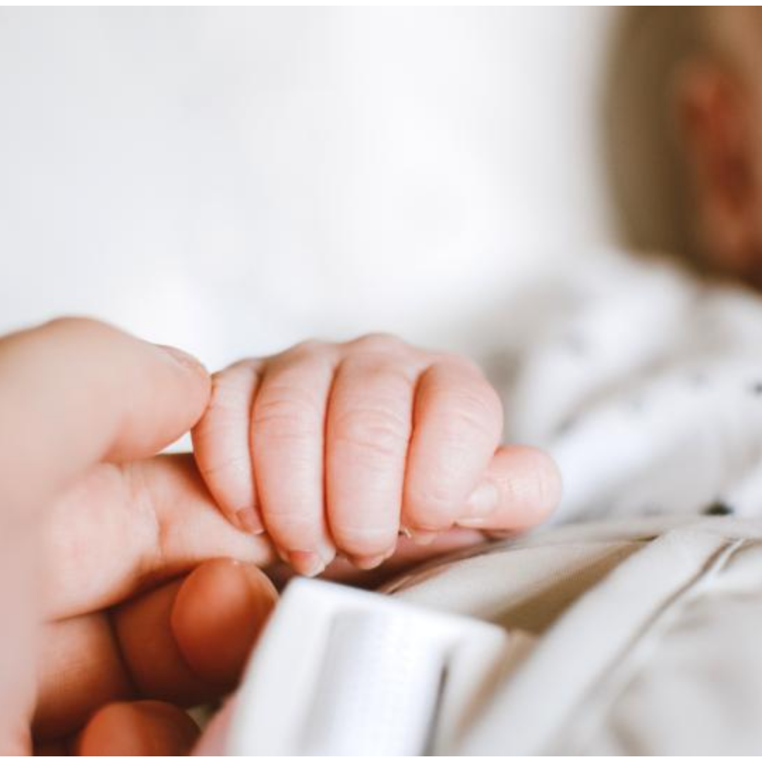 어른의 손가락을 꼭 쥐고 자는 아기