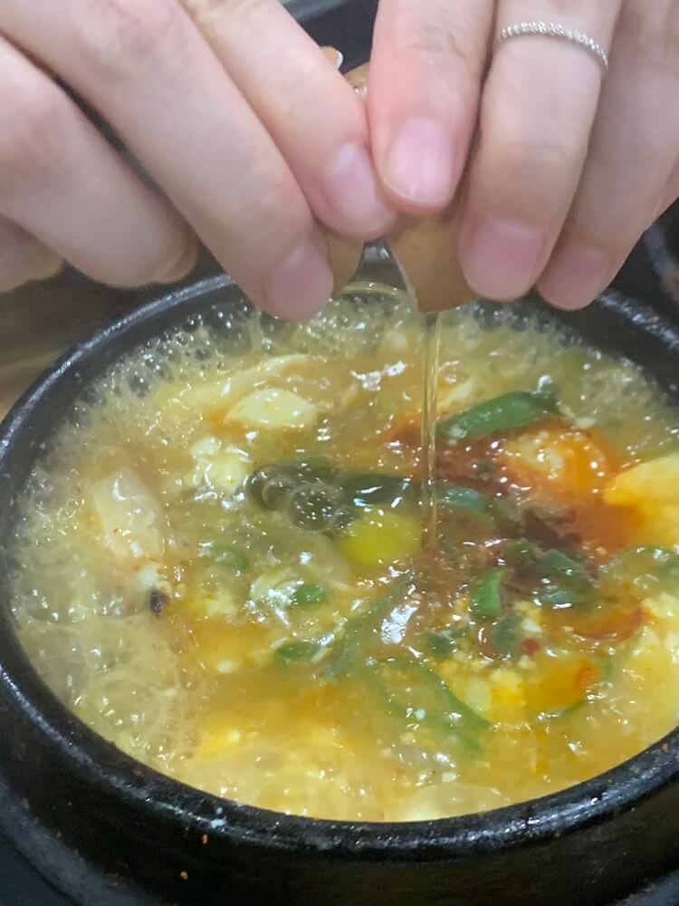 섞어 순두부에 계란 깨는 모습