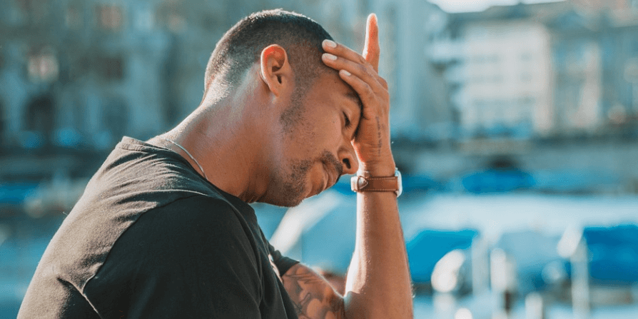 현기증을 느끼는 남자가 이마에 손을 대고 휴식을 취하고 있다