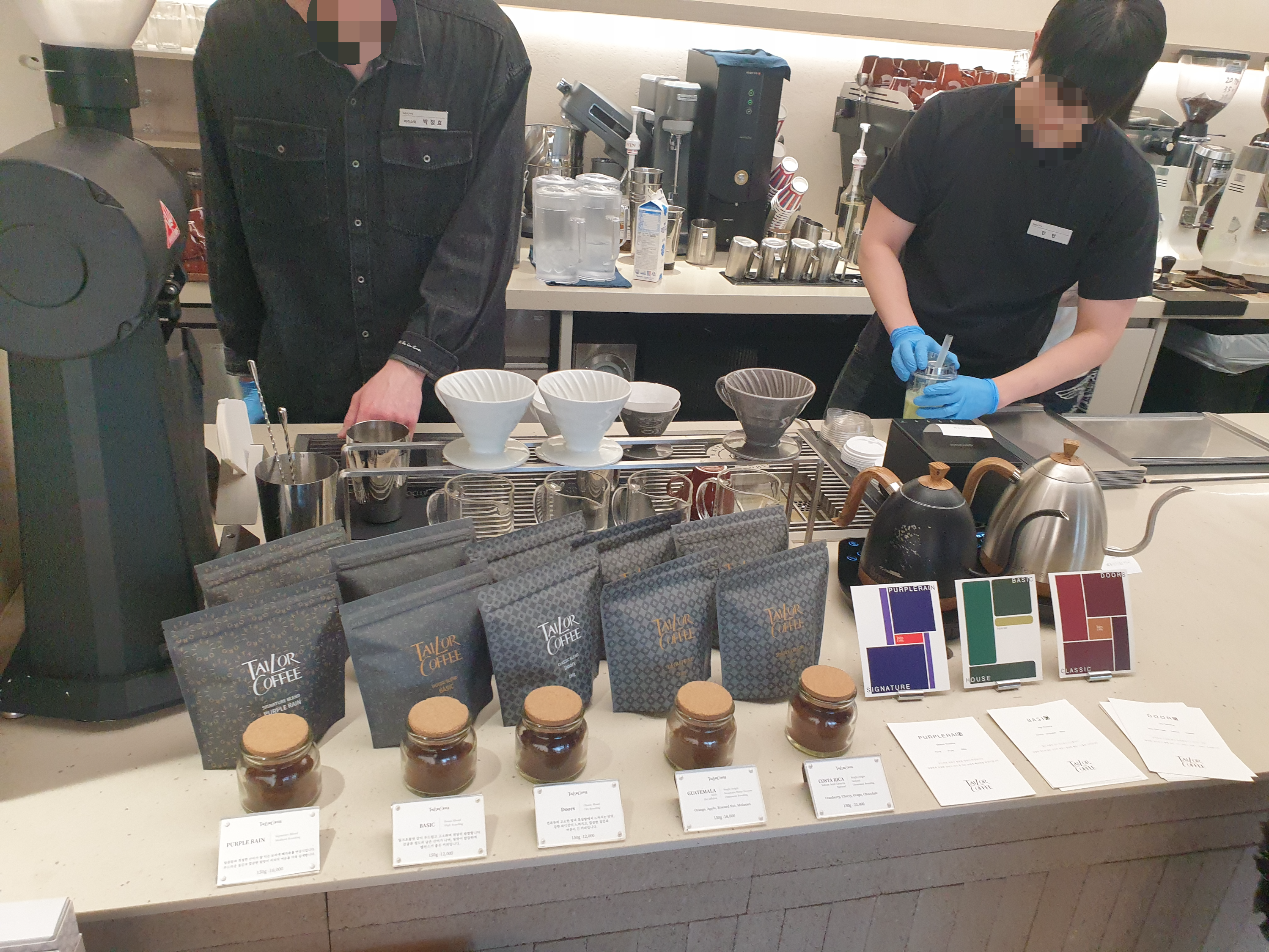 아이보리 색 대리석 상판에 각종 브루잉 장비와 판매용 원두가 놓여있다.