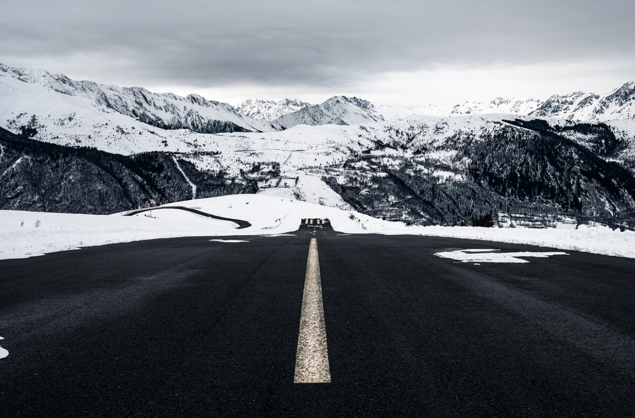 눈덮인 산에 둘러쌓인 도로