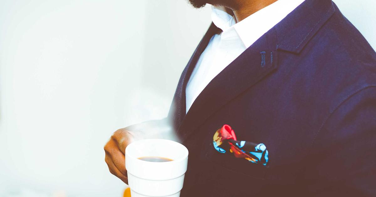 Young couple looking at apartment blueprints with a laptop, smiling
