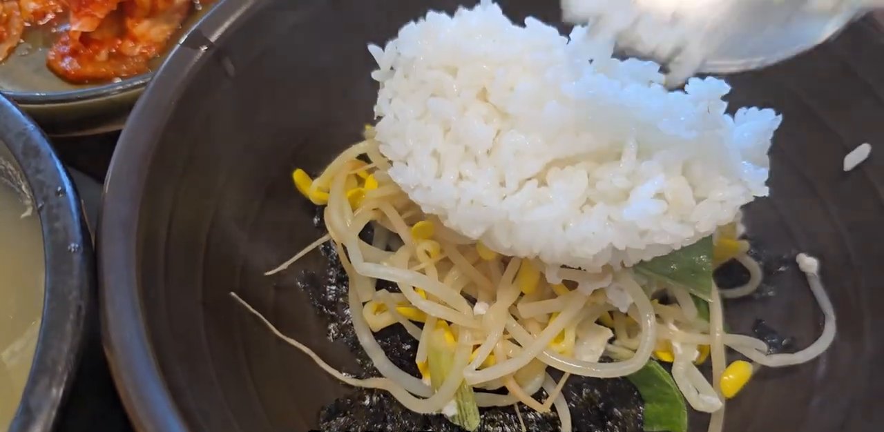 콩나물 위에 밥을 얹어 말아 줘요.