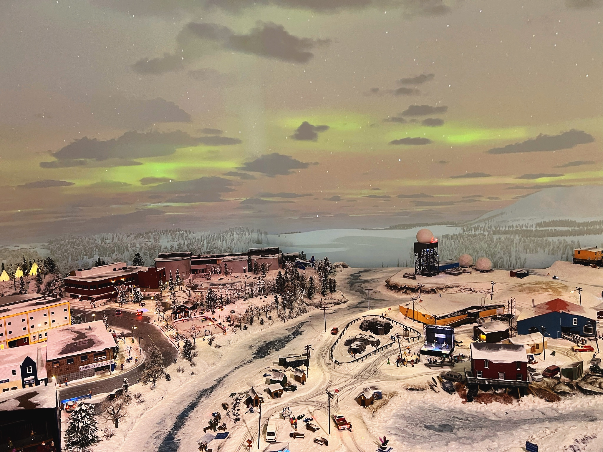 Little North miniature village at Little Canada with aurora borealis lighting, snow-covered landscape, and northern town details