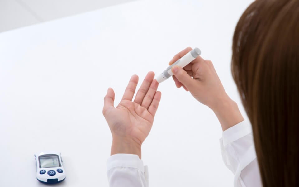 혈당체크를 위해 손가락에서 채혈하는 사진