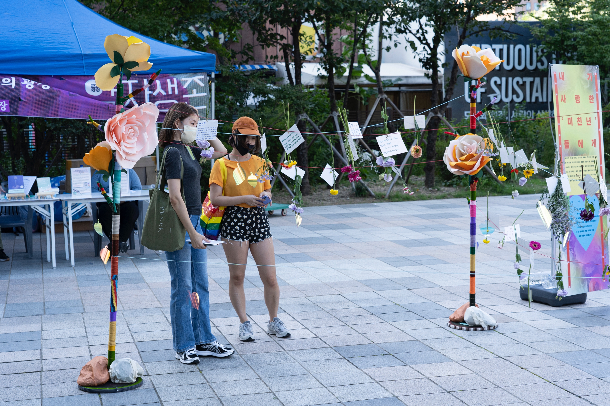 대형 꽃 구조물에 헌화한 꽃과 메시지 카드가 걸려 있다.
