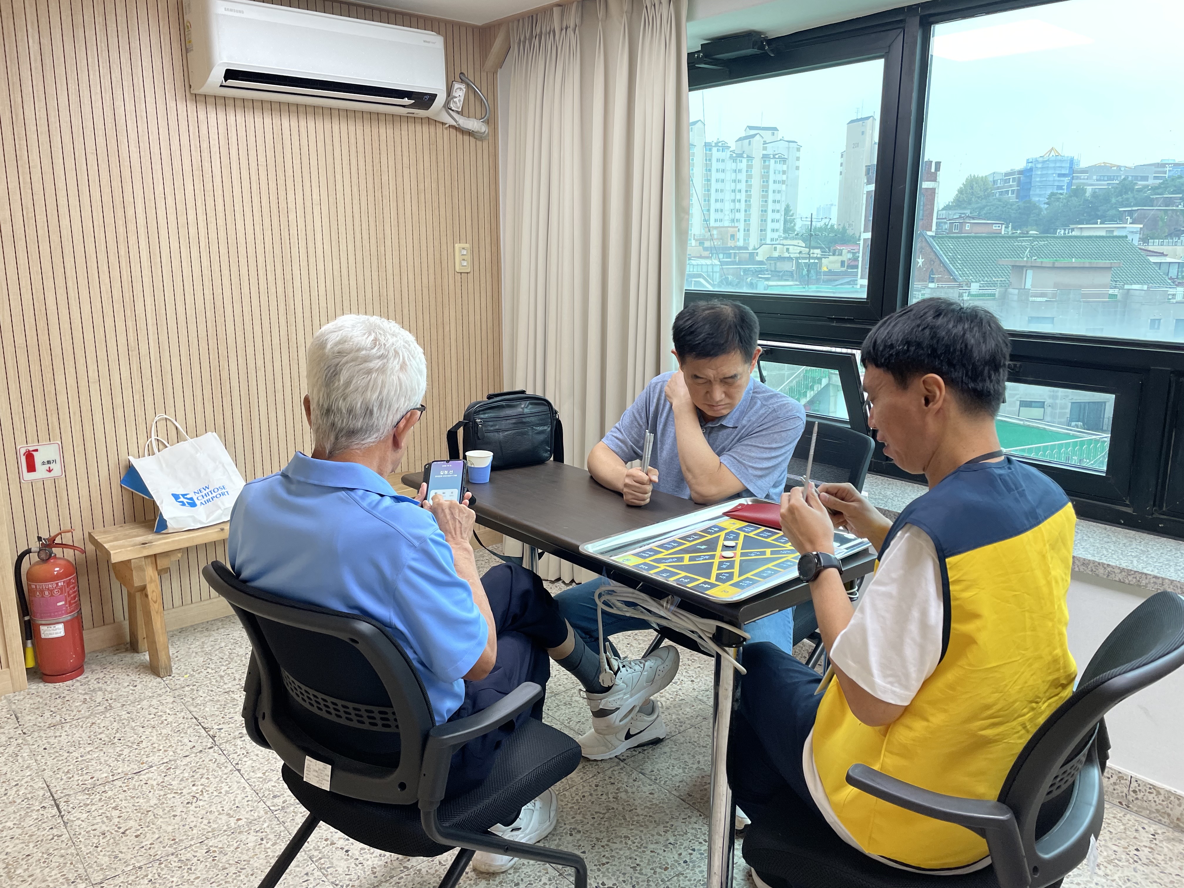 이미지 설명: 1부 윷놀이 경기사진. 김승수 지회원과 김종창 지회원이 경기중임.