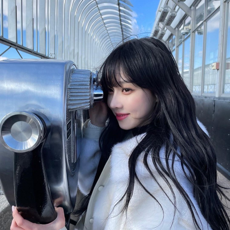 걸그룹-에스파-멤버-윈터가-동전을-넣는-망원경에-얼굴을-가까이-하고-미소짓고-있는-사진