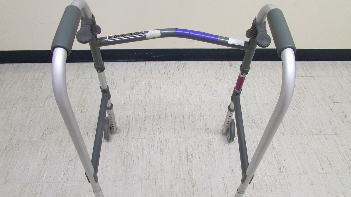 허리 보조기를 착용하고 병원 복도를 걷는 환자의 모습